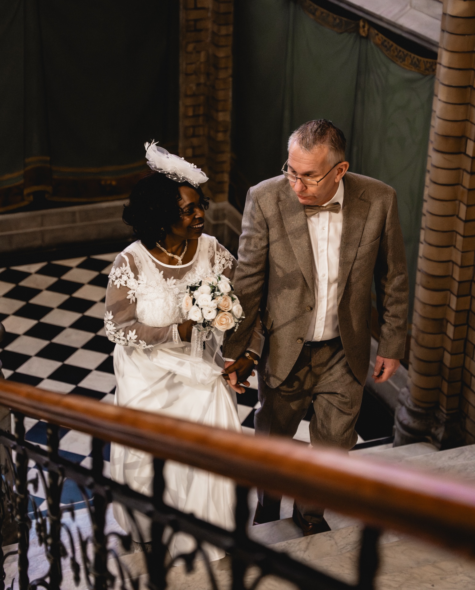 Couple walking up a marble staircase after the ceremony