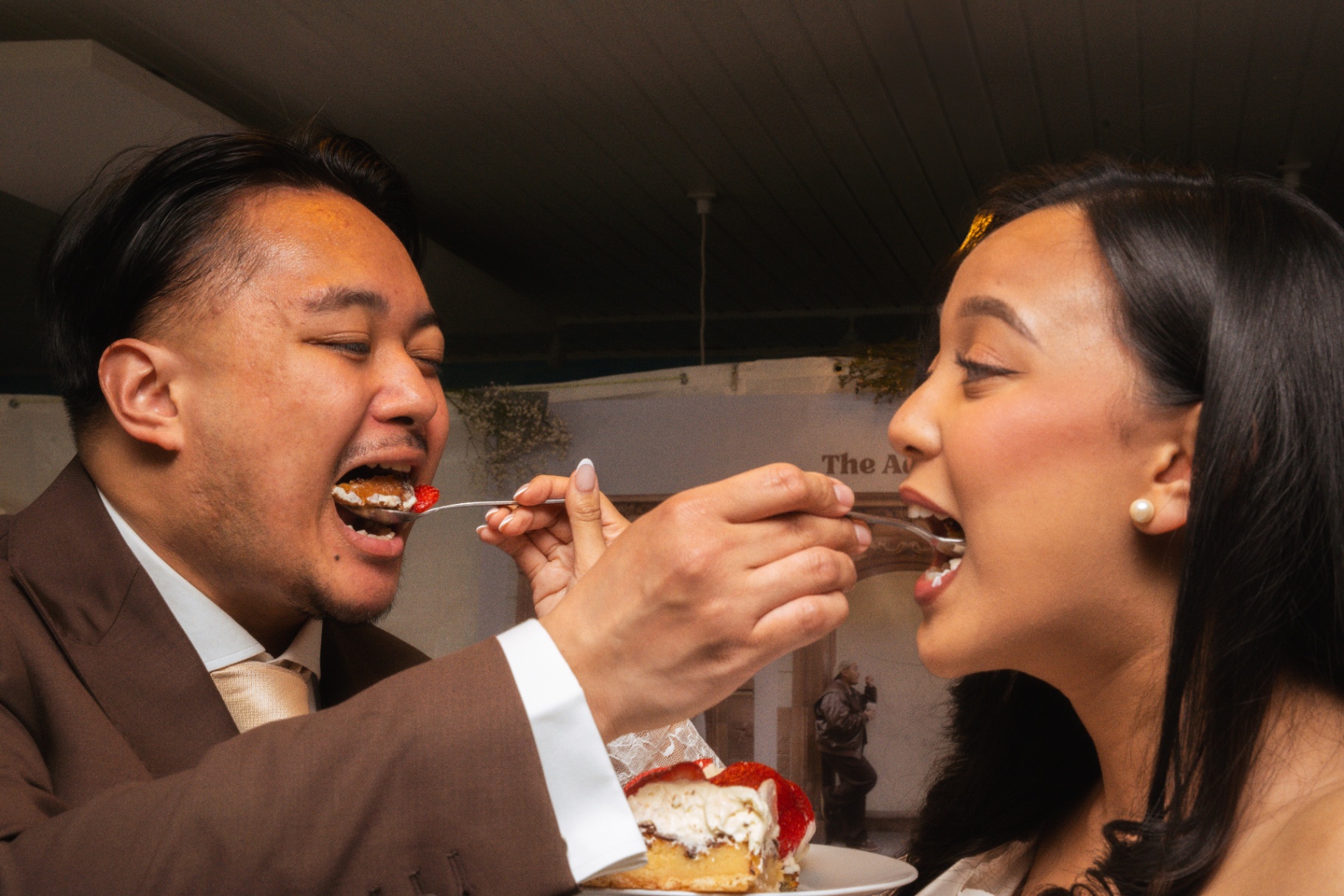 Bride and groom feeding each other cake at the reception