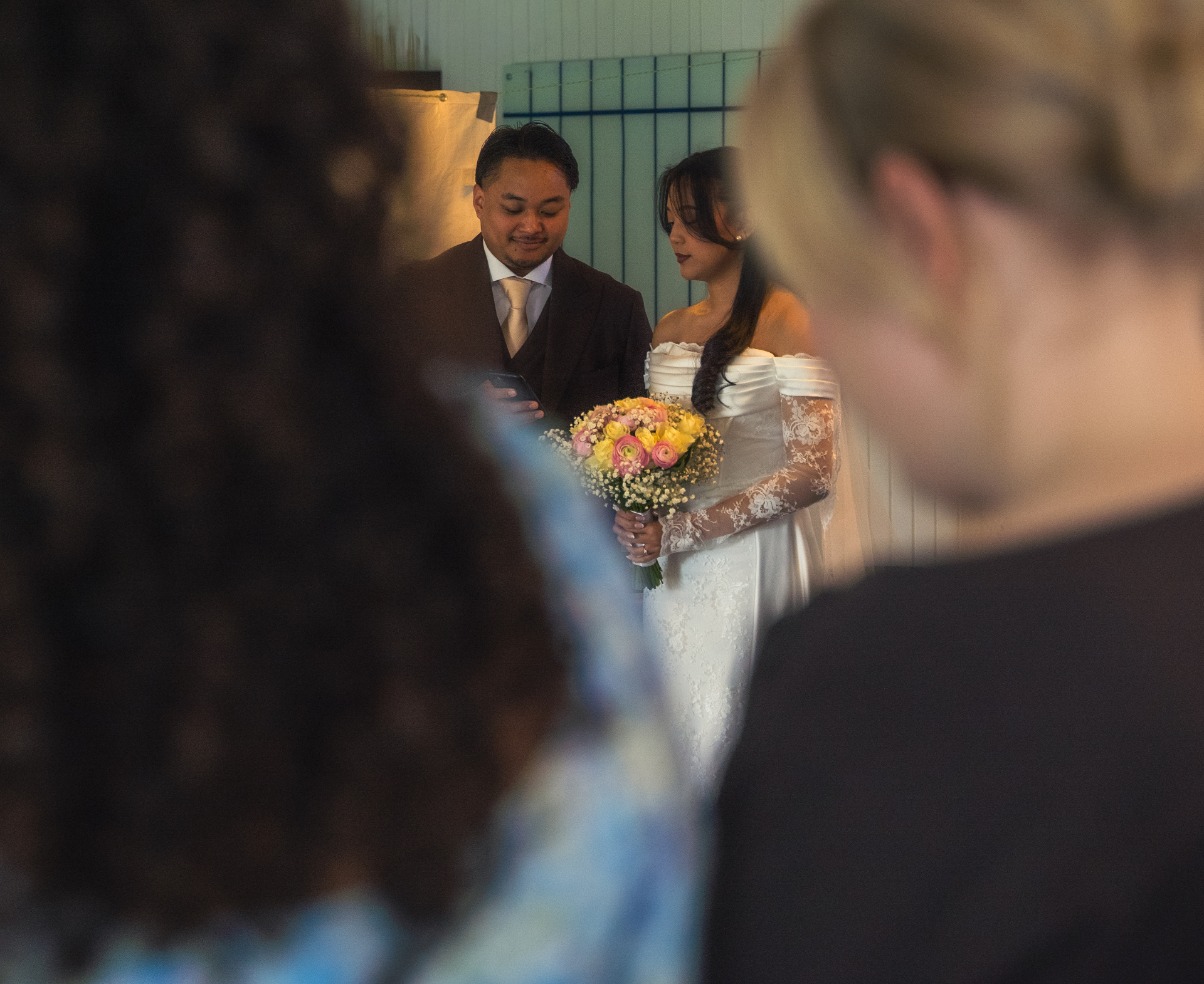 Couple during the ceremony framed softly through the guests