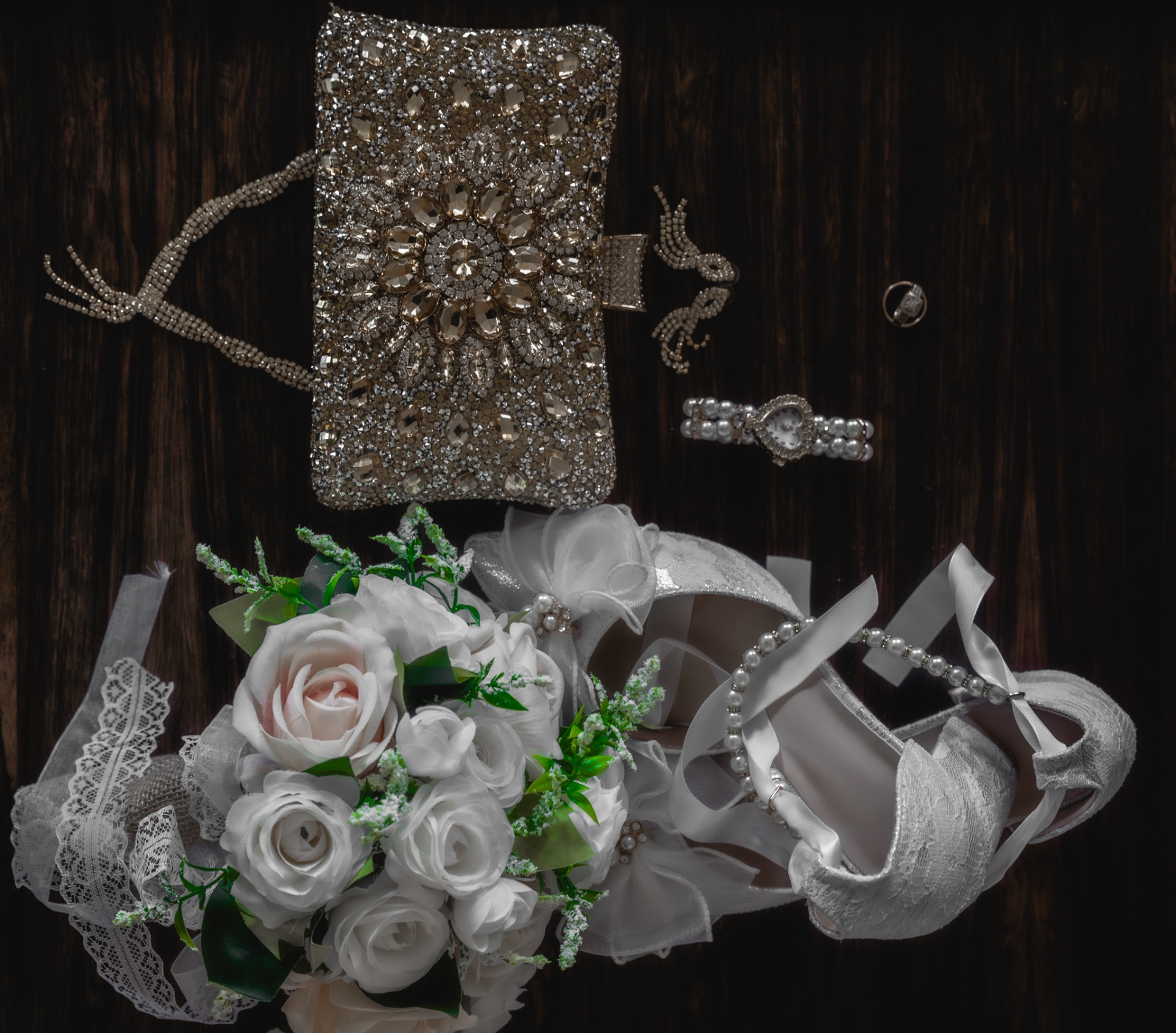 Wedding details laid out with bouquet, shoes, bracelet and clutch