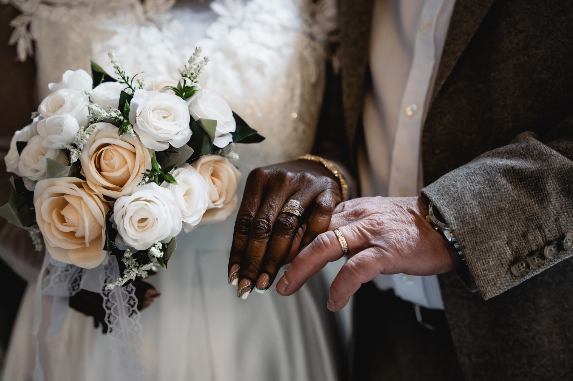 Close view of the couple's hands and rings beside the bouquet